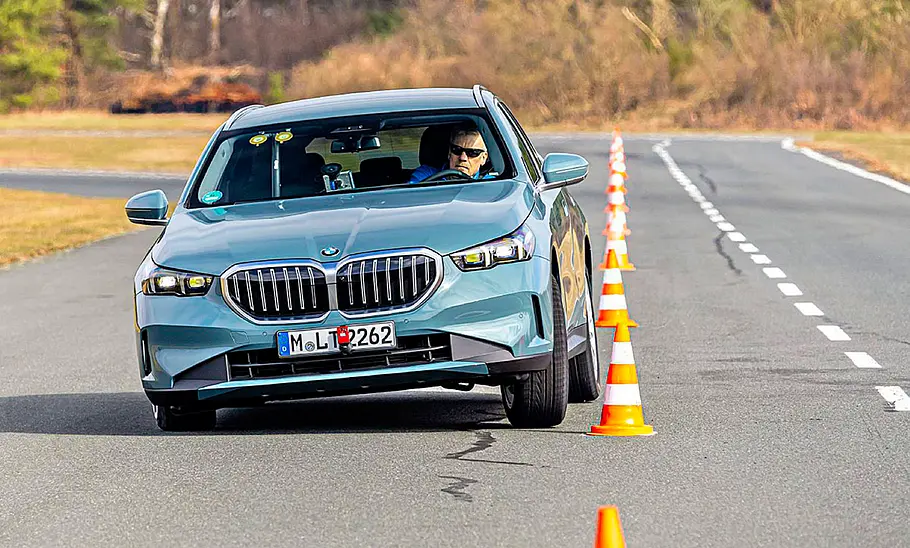 Der BMW 520d fahrend von schräg vorne fotografiert.