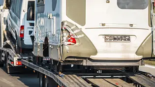 Ein beschädigtes Wohnmobil wird auf einem Lastwagen abgeschleppt. - Foto: Imago