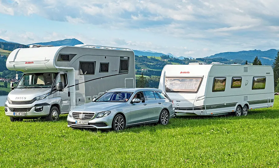 Das Bild zeigt links den Dethleffs Globetrotter XXL A und rechts den Dethleffs Nomad 650 RQT im Gespann mit einem Mercedes E-Klasse T-Modell auf einer Wiese stehend von schräg vorne links fotografiert.