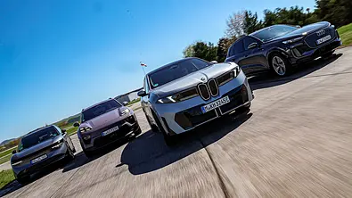 Blick von schräg vorne auf die vier fahrenden Elektro-SUV Zeekr 7X, Porsche Macan, BMW iX3 und Audi Q6. - Foto: Daniela Loof
