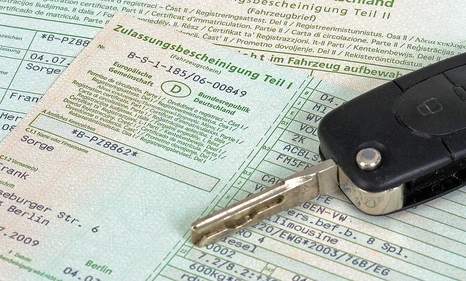 Zulassungsbescheinigung Teil 1 in Nahaufnahme mit Autoschlüssel daraufliegend.